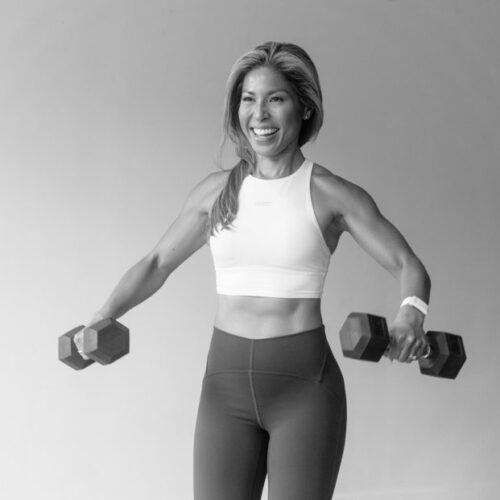 A woman with weights, smiling