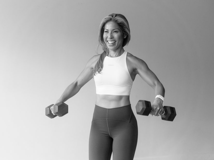 A woman with weights, smiling