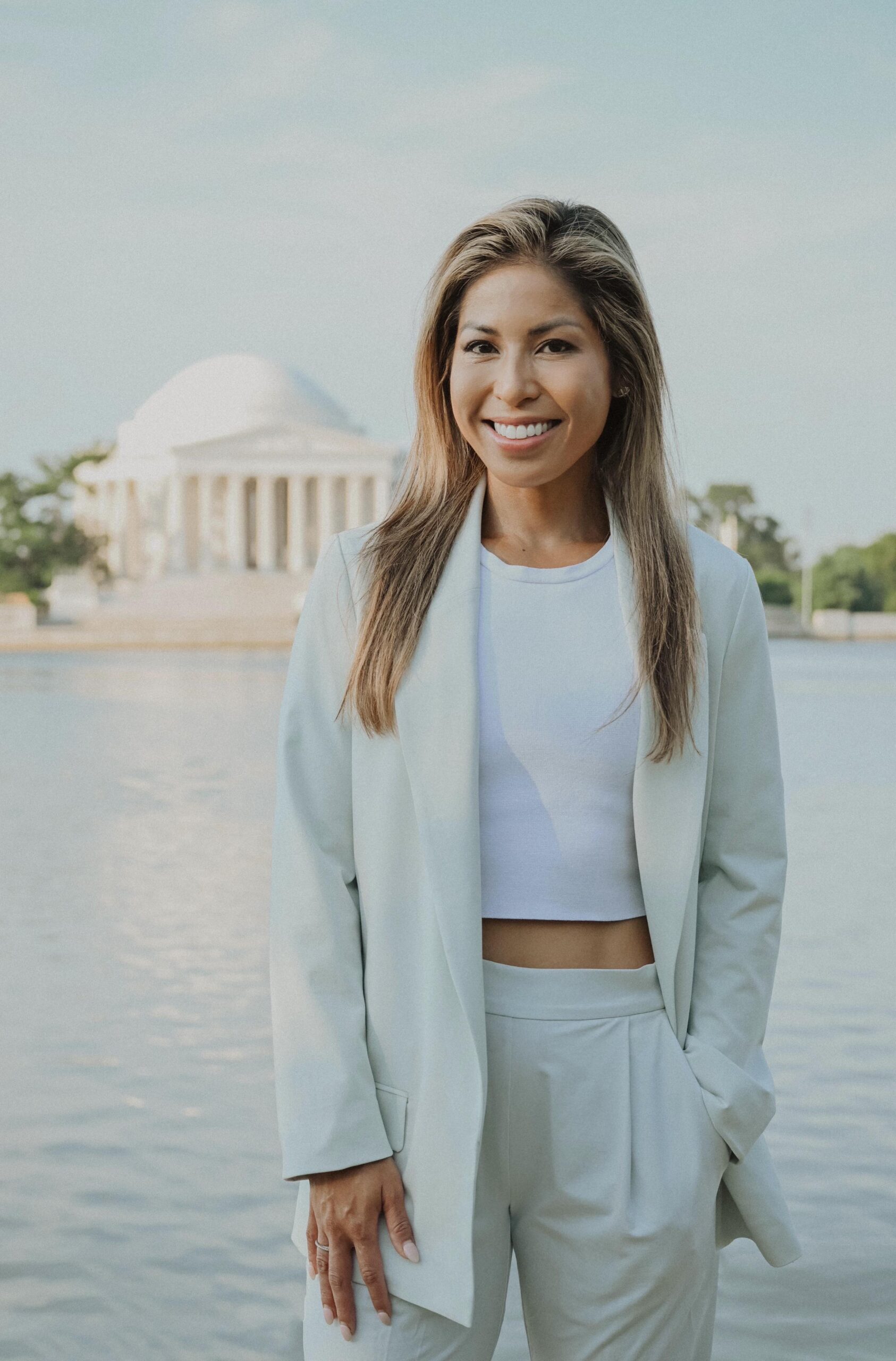 A woman smiling with the  Capitol Building behind her