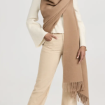 A woman wearing a white suit and a brown scarf