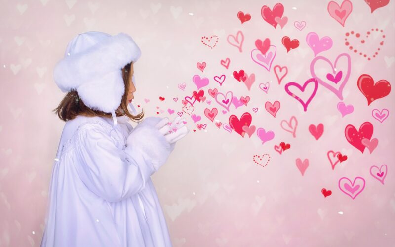 little girl appearing to blow hearts