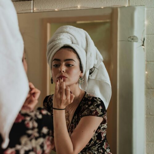 Girl applying her skincare in the mirror