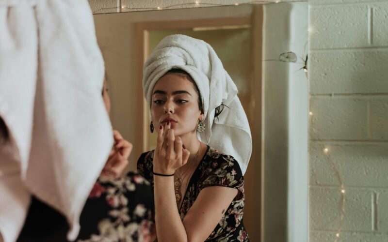 Girl applying her skincare in the mirror