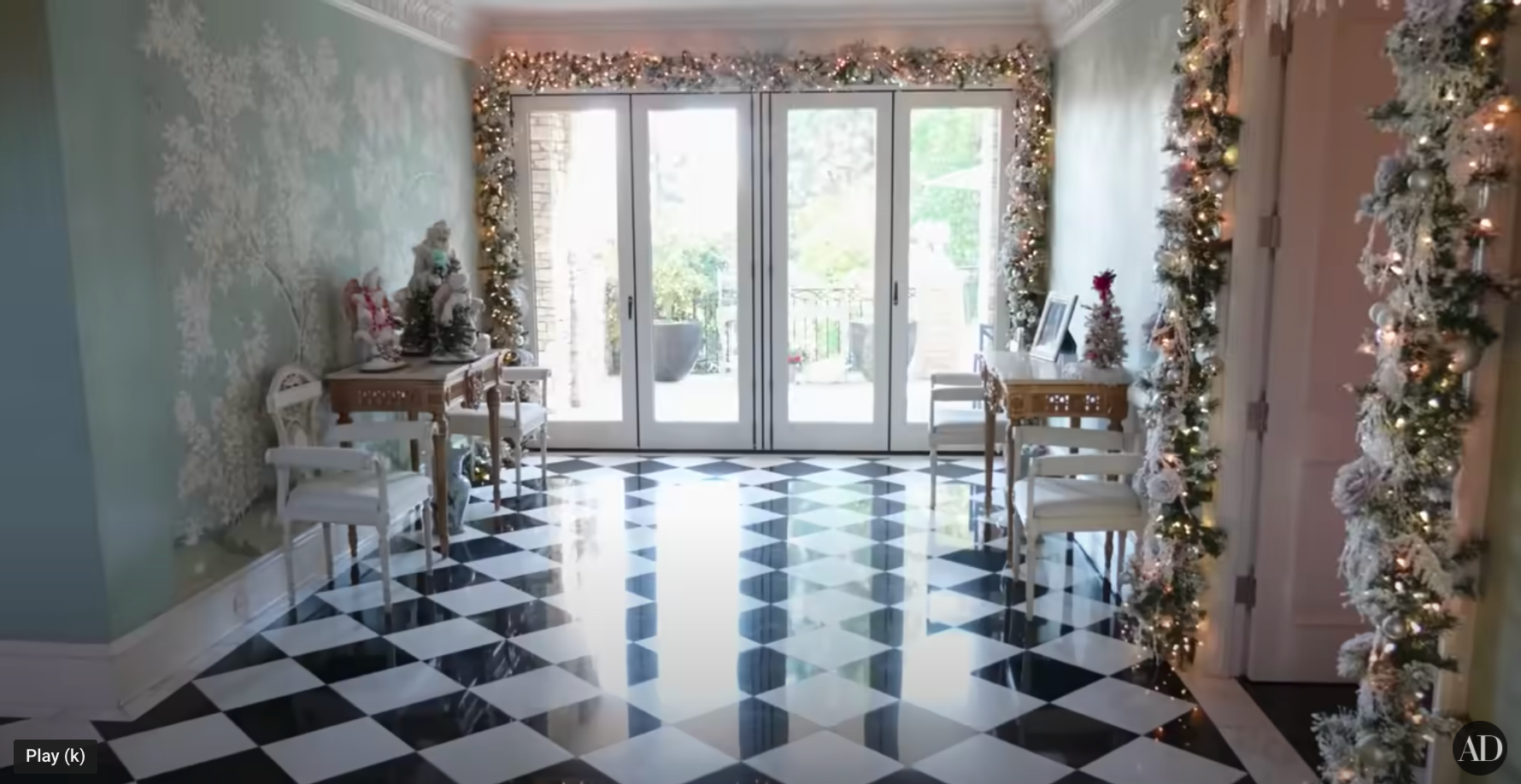 A room decorated with Christmas garlands surrounding the doorways