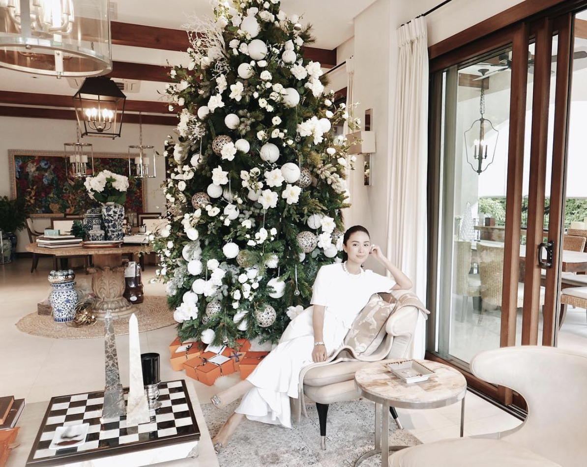 A woman sitting by her Christmas tree